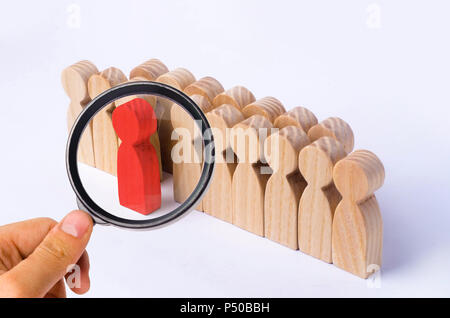 Die gewählte Person unter anderem. Eine menschliche Figur von roter Farbe hebt sich von der Masse ab. Holzfiguren von Menschen. Ein talentierter Mitarbeiter, eine erfolgreiche Choic Stockfoto