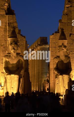 Tempel von Luxor. Nachtansicht der Kolosse von Ramses II. in den ersten Pylon des Tempels. Ägypten. Stockfoto