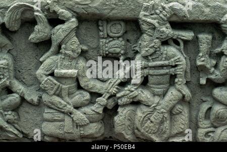 Präkolumbische Kunst. Maya. Archäologische Stätte von Copa n. Altar Q. in der West Side. Es war während der Herrschaft von König Yax Pac 776erstellt. Es gibt dargestellt 16 Führer von Copan, mit einem vollen Körper, Porträt, vier auf jeder Seite des Denkmals gezeigt. Jedes Lineal ist auf eine Glyphe, die seinen Namen stellt sitzt. Diese Szene zeigt auf Yax Pasah, der letzte Herrscher von Copan, empfangen die Fackel aus der Gründer der Dynastie, Yax Kuk Mo. Honduras. Stockfoto