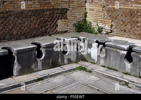 Ostia Antica. Latrine bei Domus Triclini, Sitz der Zunft der Bauherren. 2. Jahrhundert n. Chr. In der Nähe von Rom. Stockfoto