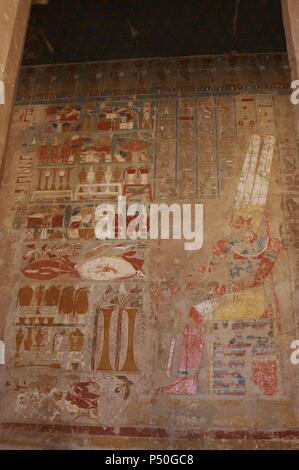 Polychrome Relief mit der Darstellung der Gott Amon, an einem Tisch der Angebote mit federkopfschmuck, Bart und auf beiden Händen das Zepter Uady und das Ankh sitzen. 18 Dynastie. Neuen Reich. Tempel der Hatschepsut. Deir el-Bahari. Ägypten. Stockfoto