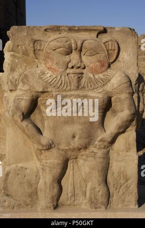 Ägyptische Kunst. Dendera. Gott Bes. Hauptstadt der Spalte. Relief auf dem Vorplatz der Tempel der Hathor. Stockfoto