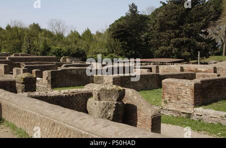 Italien. Ostia Antica. Die republikanische Store-Gebäude wurde in der Realität vermutlich ein Komplex von Läden und Werkstätten. Die Wände errichtet wurden am Ende des ersten Jahrhundert v. Chr. in Opus Reticulatum quasi. Allgemeine Ansicht von Südosten mit der Tufa piers des ursprünglichen südlichen Vorhalle. Stockfoto