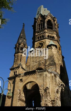 Deutschland. Berlin. Kaiser Wilhelm Gedächtniskirche. 1891-1895. Gebaut von Franz Heinrich Schwechten (1841-1924). Während des Zweiten Weltkriegs bombardiert, behält die Turmruine von Gebäuden umgeben zwischen 1951 und 1961 errichtet. Stockfoto