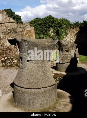 Pompeji. Antike römische Stadt. Bäckerei von Modesto. Mühlsteine hergestellt aus Basaltlava, angetrieben von Esel, um das Korn zu mahlen. Italien. Stockfoto