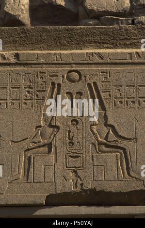 Relief zeigt Gott Amun mit toller Helm mit zwei großen Federn und Bart sitzt auf dem Thron. Ersten Hof des Ramses II. Neuen Imperiums. Tempel von Luxor. Ägypten. Stockfoto