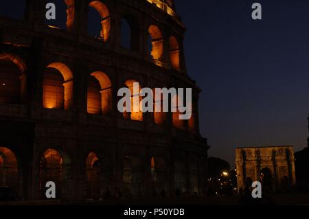 Italien. Rom. Das Kolosseum (Kolosseum) oder Flavischen Amphitheater. Elliptische Konstruktion gebaut aus Beton und Stein. 1. Jahrhundert A.C. Nächtliche Ansicht. Im Hintergrund, der Triumphbogen des Konstantin. Stockfoto