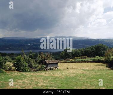 Spanien. Galizien. Überblick über eine typische galizische Landschaft mit Reservoir von Das Conchas im Hintergrund. In der Nähe von Santa Comba de Bande. Stockfoto