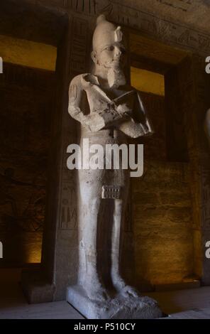 Ägyptische Kunst Großen Tempel von Ramses II (1290-1224 v. Chr.). Grabkunst Tempel in den Fels gehauen. Blick aus dem ersten Zimmer, mit einem der acht Statuen von Ramses II. als der Gott Osiris. Abu Simbel. Ägypten. Stockfoto