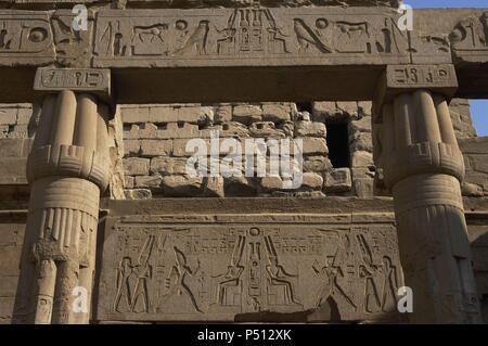 Relief zeigt Gott Amun mit toller Helm mit zwei großen Federn und Bart sitzt auf dem Thron. Ersten Hof des Ramses II. Neuen Imperiums. Tempel von Luxor. Ägypten. Stockfoto