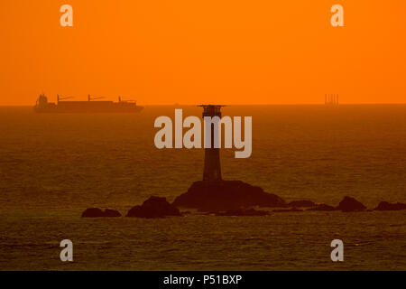 Ein Schiff fährt vorbei Longships Lighouse bei Lands End vor der Küste von Cornwall Stockfoto