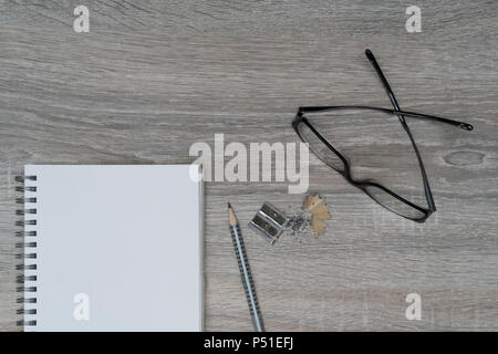 Der Schreibtisch mit Brille, einem Bleistift und einem Klemmbrett Stockfoto