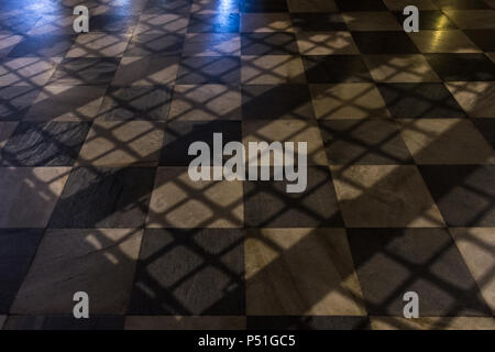 Kariertem Boden mit stimmungsvollen Licht und Zelle Bar Schatten Stockfoto