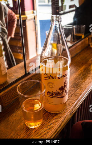 Ein Glas und eine Flasche bretonischen Cidre eine Leiste am French House Bar Brasserie, Dean Street, London, England Stockfoto