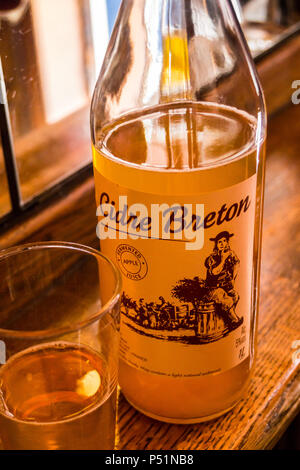 Ein Glas und eine Flasche bretonischen Cidre eine Leiste am French House Bar Brasserie, Dean Street, London, England Stockfoto