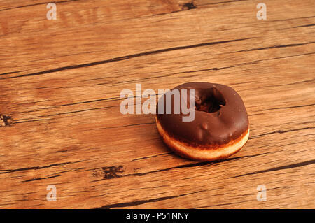 Eine Schokolade Donut auf einer hölzernen Tabelle angezeigt Stockfoto