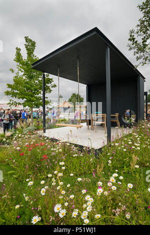 Menschen sehen gepflasterte Pavillon Sitzecke, Swing & bunten wildflowers - Ccla: eine Familie Garten, RHS Chatsworth Flower Show, Derbyshire, England, UK. Stockfoto