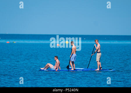 24. Juni 2018. Aberystwyth Wales UK UK Wetter: Junge Männer Paddle Boarding am Sonntag Morgen auf dem ruhigen Wasser der Cardigan Bay in Aberystwyth auf einem hellen und sonnigen Tag, wie die BRITISCHE Köpfe in ein mini Hitzewelle mit Temperaturen um 29° oder 30° Celsius bis Mitte der Woche Foto © Keith Morris Credit Hit: Keith Morris/Alamy leben Nachrichten Stockfoto