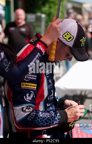 Dalton auf T-Stücke, England, 24. Juni 2018. Dunlop MSA British Touring Car Championship Driver Tom Ingram Unterzeichnung ein Hut für Zuschauer während einer Grube Spaziergang im Croft. Credit: Colin Edwards/Alamy Leben Nachrichten. Stockfoto