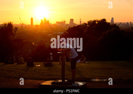 London, Großbritannien. 24. Juni, 2018. Ein Junge Getränke aus einem Brunnen am Telegraph Hill, South London, während die Sonne über der Stadt in einem heißen Abend einstellt, da das Wetter Temperaturen über 25 C in Großbritannien heute am Sonntag, den 24. Juni 2018 erreicht. Credit: Isabel Infantes/Alamy leben Nachrichten Stockfoto