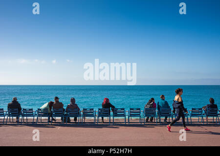 Schöne Stadt in Frankreich, Menschen auf Stühlen entspannen am Meer an der Promenade des Anglais, Französische Riviera - Cote d'Azur Stockfoto