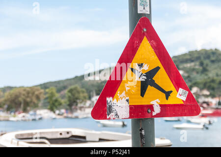 Skiathos, Griechenland. 15. Juni 2018: Verkehrswarnschild auf der Straße, das niedrige Flugzeuganzeige anzeigt. Skiathos Flughafen ist bekannt als die 2. Straße. Maarten Stockfoto