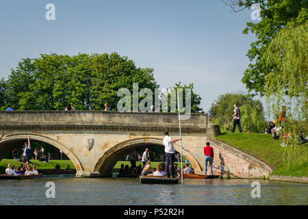 Menschen auf Punt Boote stochern auf dem Fluss Cam in der Nähe einer Brücke aus Stein an einem sonnigen Nachmittag, Cambridge, Großbritannien Stockfoto