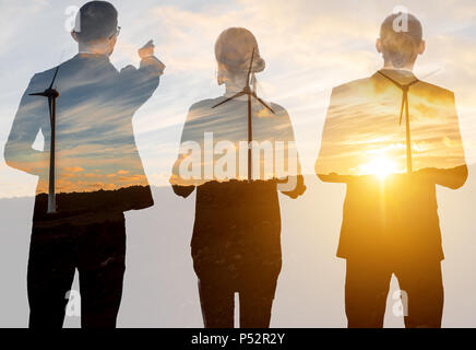 Doppelte Belichtung mit Geschäftsleuten und Windkraftanlagen Stockfoto