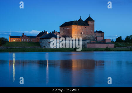 Schöne Aussicht des 13. Jahrhunderts Häme Schloss und seine Reflexionen über Vanajavesi-sees in Hämeenlinna, Finnland, am Abend beleuchtet. Stockfoto