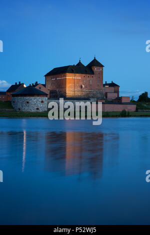 Schöne Aussicht des 13. Jahrhunderts Häme Schloss und seine Reflexionen über Vanajavesi-sees in Hämeenlinna, Finnland, am Abend beleuchtet. Stockfoto