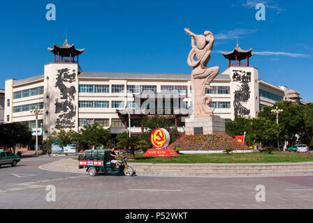 Dunhuang, China - August 7, 2012: Street Scene in der Stadt Dunhuang, mit einem Kreisverkehr mit einer Statue eines Apsara spielen eine Pipa und die chinesischen Co Stockfoto