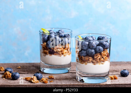 Blueberry Dessert, Käsekuchen, Kleinigkeit, Müsli in einem Glas auf Holz vintage Tabelle mit Rissen. Stockfoto