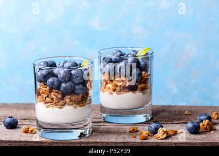 Blueberry Dessert, Käsekuchen, Kleinigkeit, Müsli in einem Glas auf Holz vintage Tabelle mit Rissen. Stockfoto