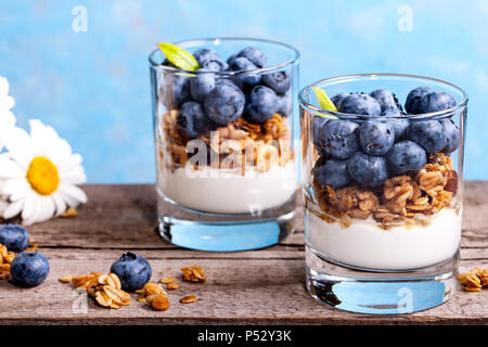 Blueberry Dessert, Käsekuchen, Kleinigkeit, Müsli in einem Glas auf Holz vintage Tabelle mit Rissen. Stockfoto