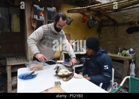 Februar 7, 2017 - Breil-sur-Roya, Frankreich: Cedric Herrou hat Mittagessen mit Mohamed Sadeq, eine junge sudanesische Zuwanderer, der drei Tage zuvor in der Roya Valley angekommen. Cedric Herrou dejeune Chez Lui avec Mohamed Sadeq, un jeune Migrant soudanais ankommen Trois jours plus tot dans la Vallee de La Roya. Stockfoto