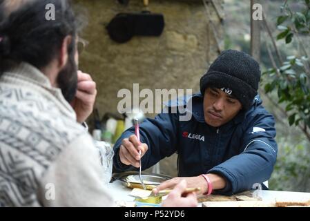 Februar 7, 2017 - Breil-sur-Roya, Frankreich: Cedric Herrou hat Mittagessen mit Mohamed Sadeq, eine junge sudanesische Zuwanderer, der drei Tage zuvor in der Roya Valley angekommen. Cedric Herrou dejeune Chez Lui avec Mohamed Sadeq, un jeune Migrant soudanais ankommen Trois jours plus tot dans la Vallee de La Roya. Stockfoto