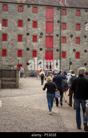 Touristen während Jameson erleben geführte Tour im Innenhof der Old Jameson Whiskey Distillery in Midleton, Irland. Stockfoto