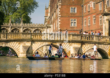 Menschen auf Punt Boote punting on the River Cam als Menschen zusammen eine Brücke von St. Johns College Universität an einem sonnigen Nachmittag, Cambridge, UK Stockfoto