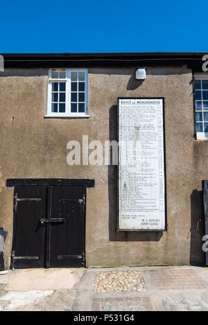 LYME Regis, Dorset, Großbritannien, 14. Juni 2018: Aushang der Liste Landing Preise verschiedener Güter im Cobb Hafen. Vom 1879. Stockfoto