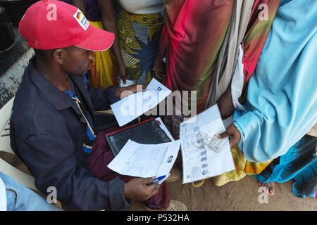 Kakuma, Kenia - Ein Mitarbeiter der Hilfsorganisation Lokado steuert die Kakuma Flüchtlingslager mit Hilfe der UNHCR Flüchtlingslager Karte. Stockfoto