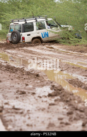 KAKUMA, KENIA - EIN UN-Land Rover hat auf einem Feldweg tief im Schlamm. Stockfoto