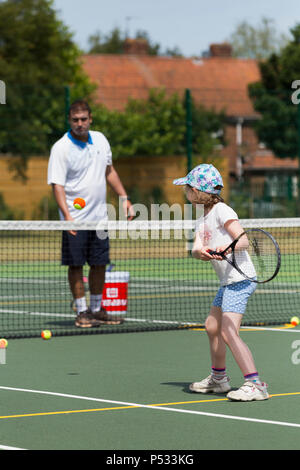 Kinder tennis Coaching/Lektion statt auf einen Tennisplatz mit Kindern/Kindern und professionellen Tennistrainer, im Sommer. UK. (99) Stockfoto