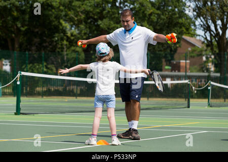 Kinder tennis Coaching/Lektion statt auf einen Tennisplatz mit Kindern/Kindern und professionellen Tennistrainer, im Sommer. UK. (99) Stockfoto