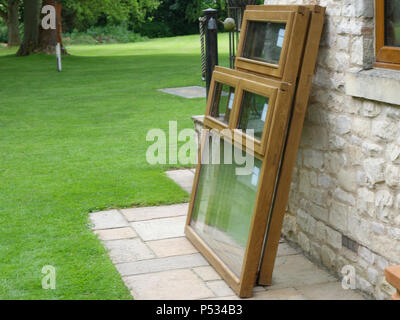 Drei neue doppelt verglaste Massiv eiche Fensterrahmen installiert werden und alte uPVC-Kunststoff Holz Fensterrahmen in einem Heim ersetzen Stockfoto