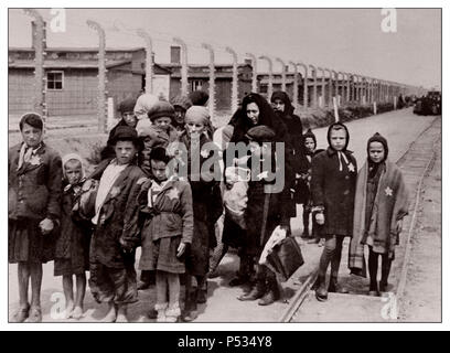 AUSCHWITZ Jüdische Kinder, die von den Nazis bezeichnete gelbe Sterne tragen, kommen in Auschwitz-Birkenau an. Ein deutsches Konzentrations- und Vernichtungslager der Nazis von WW2. Jüdische Kinder ließen die größte Gruppe in das Lager deportiert. Sie wurden in der Regel zusammen mit Erwachsenen ab Anfang 1942 als Teil der „endgültigen Lösung der jüdischen Frage“ dorthin geschickt Die totale Zerstörung der jüdischen Bevölkerung Europas...das Konzentrationslager Auschwitz war ein Netzwerk von deutschen Nazi-Konzentrationslagern und Vernichtungslagern, die vom Dritten Reich in polnischen Gebieten errichtet und betrieben wurden, die während des Zweiten Weltkriegs von Nazi-Deutschland annektiert wurden Stockfoto