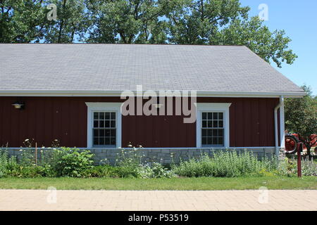 Alte rote Scheune mit weißen Fenstern. Stockfoto