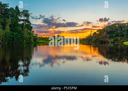 Spiegelung eines Sonnenuntergangs im Amazonas-Regenwald-Becken. Länder Brasiliens, Boliviens, Kolumbiens, Ecuadors, Perus, Venezuela, Guyana und Surinam. Stockfoto