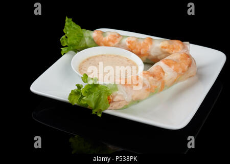 Vietnamesische Gericht Nem cuon Frühlingsrollen mit Soße auf Rechteckige weiße Platte auf Schwarz reflektierende Hintergrund isoliert Stockfoto