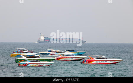 PATTAYA, THAILAND, Apr 29 2018, die schnelle Motorboote Anker am Ufer, ein Frachtschiff Segel am Horizont. Stockfoto