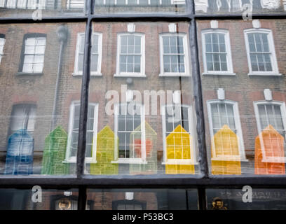 Fenster der Hugenotten Haus auf Princelet Street, Spitalfields, London, anzeigen Reflexionen der Gebäude gegenüber und schrulligen regenbogenfarbenen Modell Häuser Stockfoto